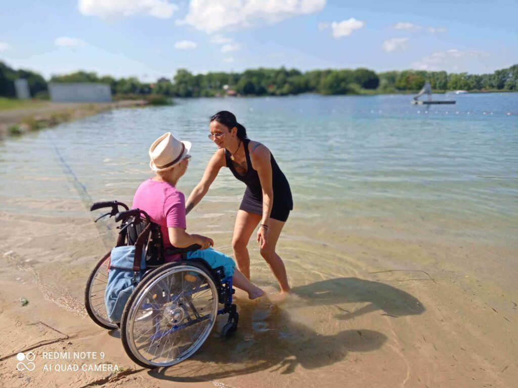 Hier siehst du meine Klientin im Rollstuhl am Strand.