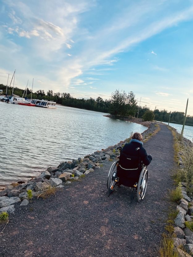 Hier siehst du meine Klientin im Rollstuhl am See.